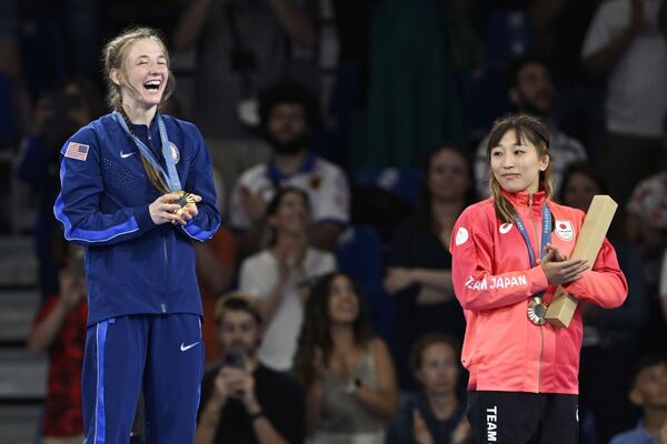 女子50kg級の表彰式で、金メダルを獲得した米国のサラアン・ヒルデブラント（左）を見つめる銅メダルの須崎優衣