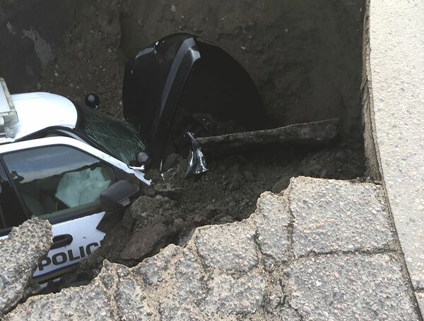 この写真は米コロラド州の陥没事故で穴に落ちたパトカー（提供：Sheridan Police Department/ロイター/アフロ）
