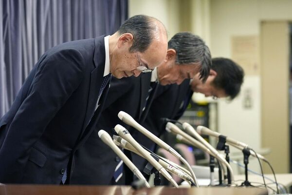 羽田空港での衝突事故を受け、2日深夜に国土交通省で記者会見を開き、頭を下げる日本航空の堤正行常務執行役員(手前)ら(写真:共同通信社)