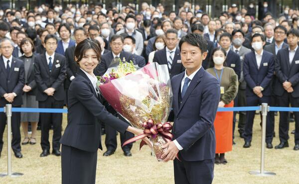 兵庫県庁での就任式で、花束を受け取る斎藤元彦知事（右）＝19日午前（写真：共同通信社）