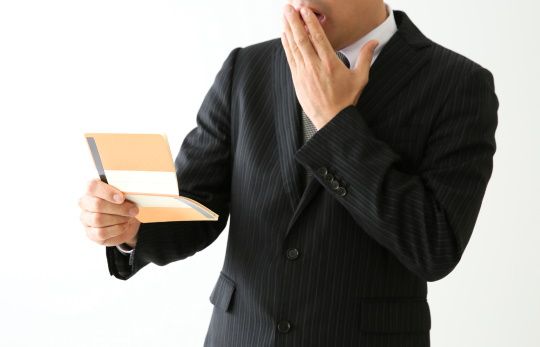 預金通帳を見る男性